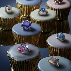 rings with colored gems on top of cupcakes